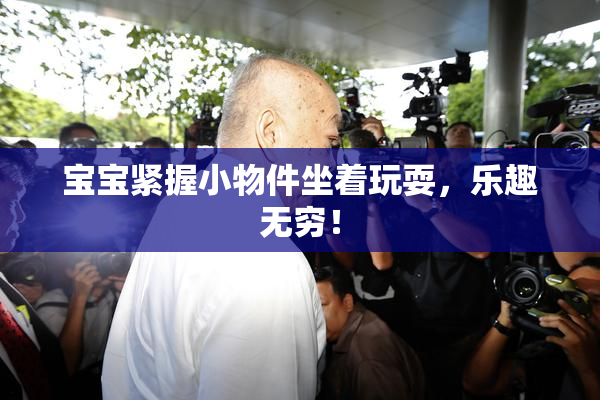 宝宝紧握小物件坐着玩耍，乐趣无穷！